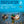 Two mallard ducks with green heads and brown feathers swim on a calm water surface. Above them, large blue text reads 